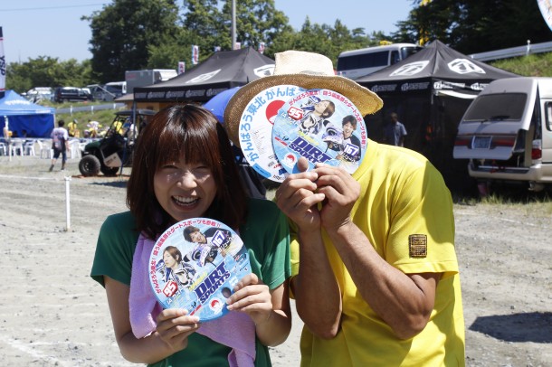 会場の人達に少しでも元気をあげたいという事で、ダートスポーツで団扇を無料配布しました。ちなみに頑張って配ってくれたのは新人ヒロマツ（写真左）